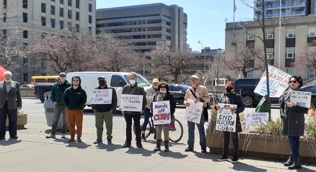 Supporters hold signs reading "End the blockade" and "Hands off Cuba" at an April 2022 solidarity rally in downtown Toronto